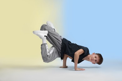 Photo of Boy in stylish clothes dancing on color background