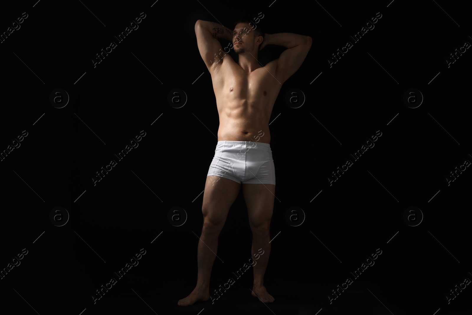 Young man in stylish white underwear on black background Photo of Young man in stylish white underwear on black background