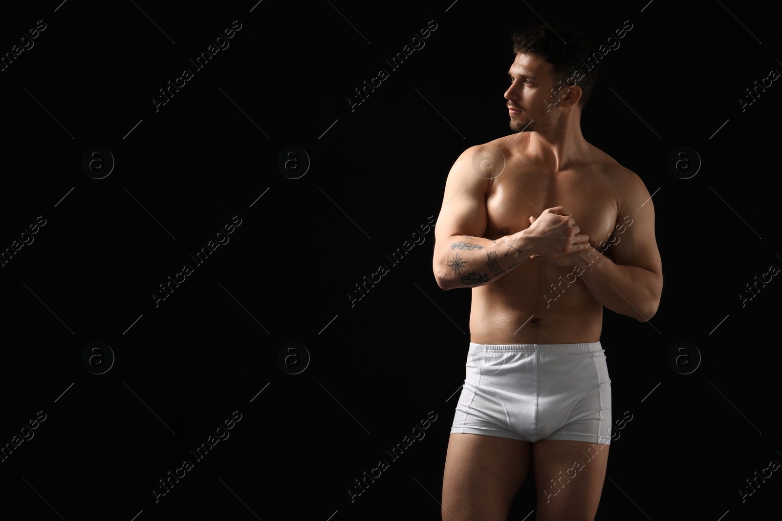 Young man in stylish white underwear on black background. Space for text Photo of Young man in stylish white underwear on black background. Space for text