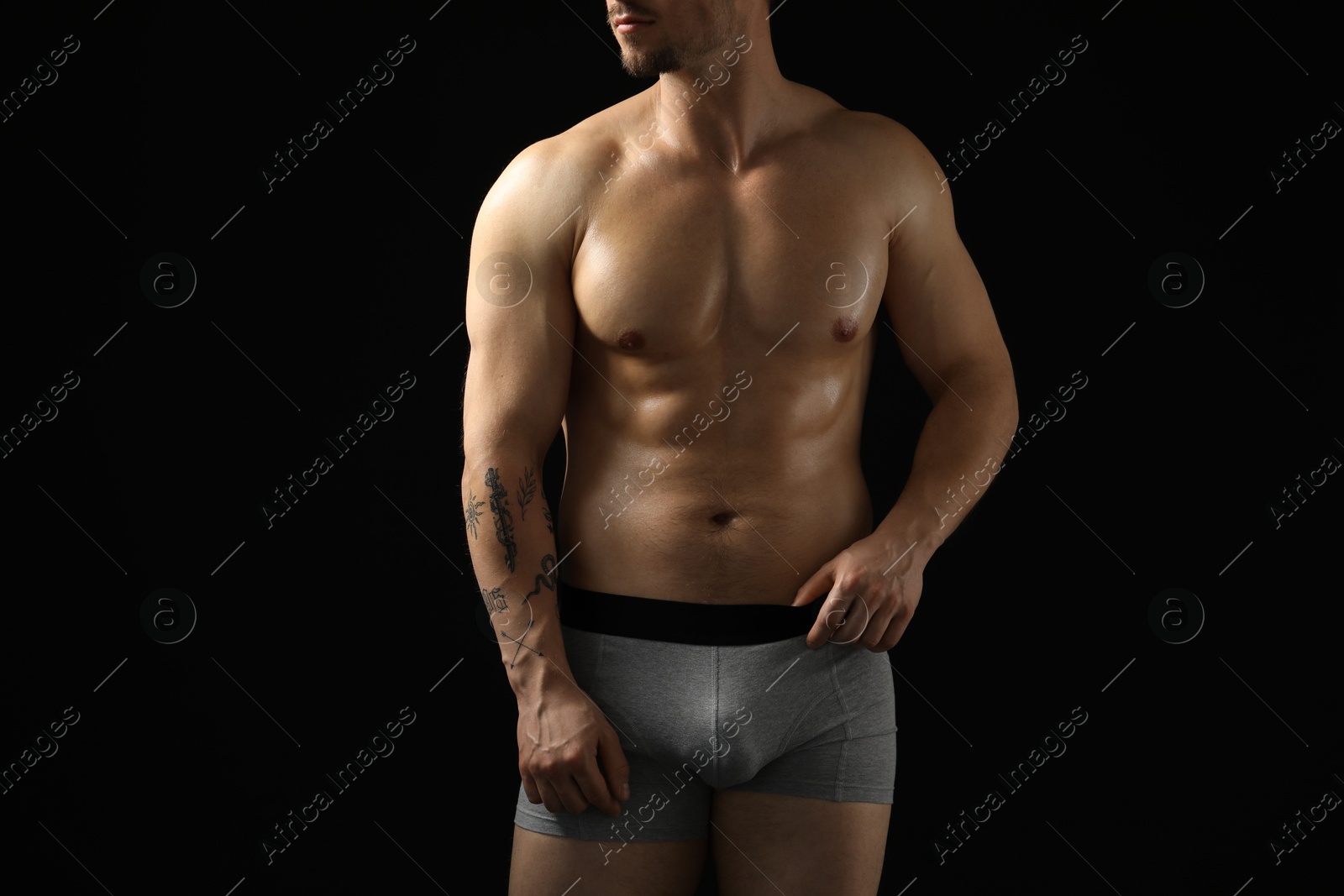 Young man in stylish light grey underwear on black background, closeup Photo of Young man in stylish light grey underwear on black background, closeup