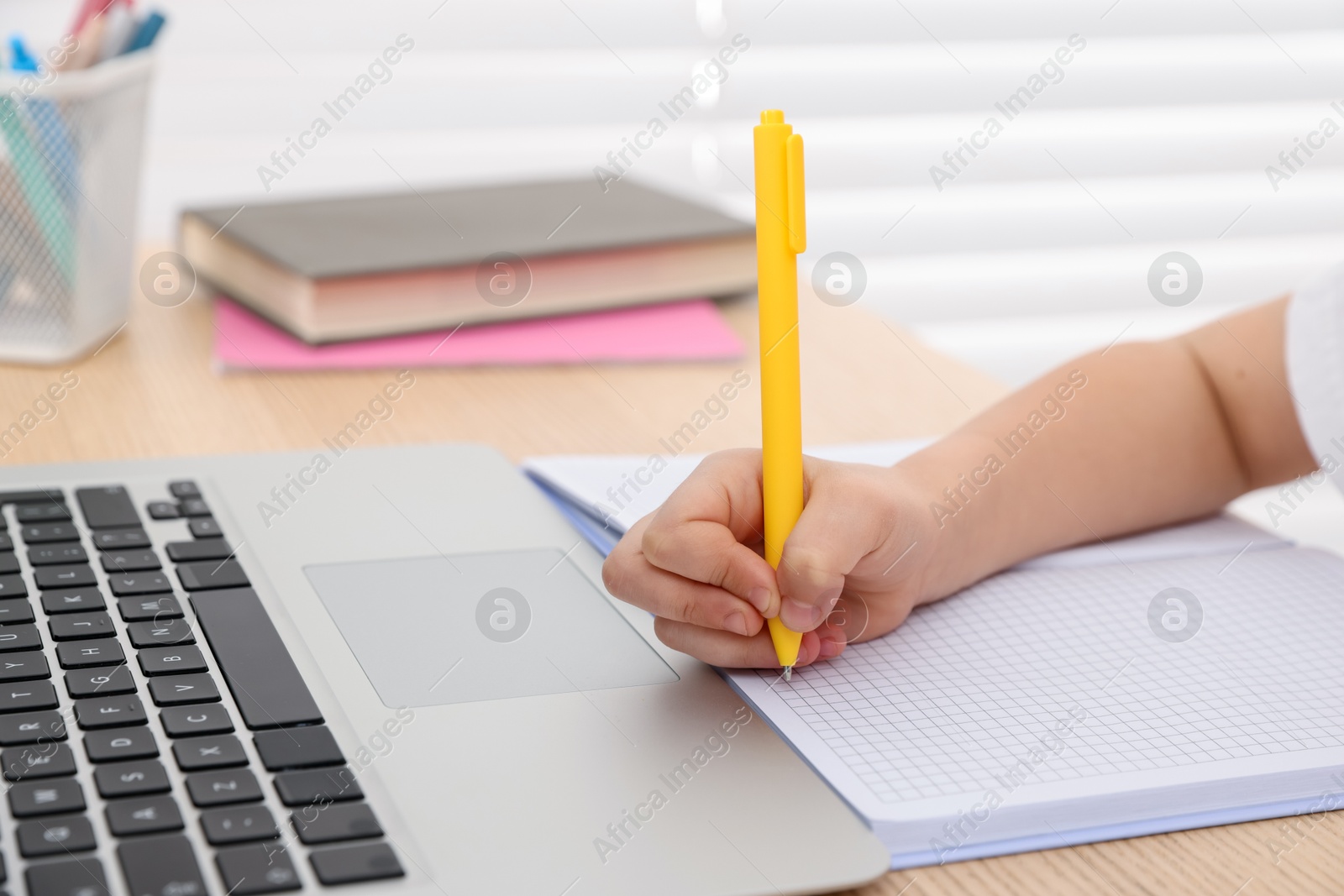Little girl doing homework at table indoors, closeup Photo of Little girl doing homework at table indoors, closeup