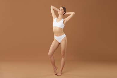 Photo of Beautiful woman with perfect slim body on beige background