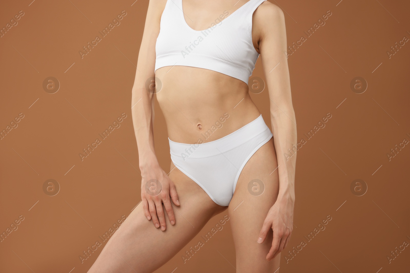 Woman with perfect slim body on beige background, closeup Photo of Woman with perfect slim body on beige background, closeup