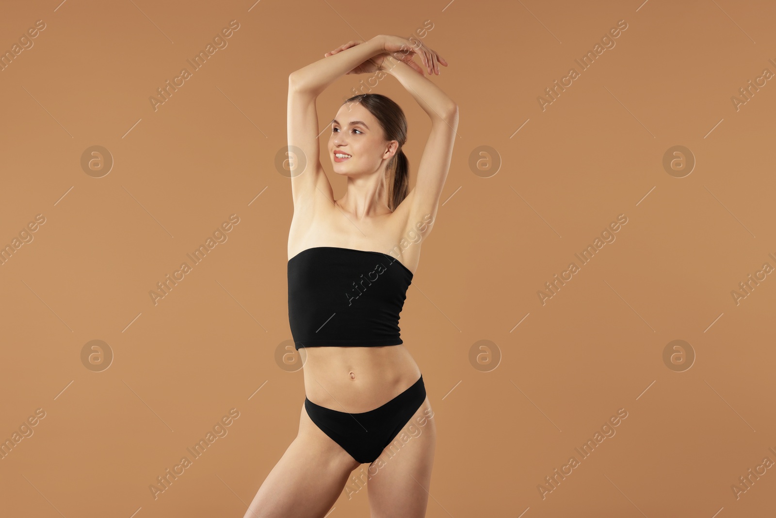 Beautiful woman with perfect slim body on beige background Photo of Beautiful woman with perfect slim body on beige background