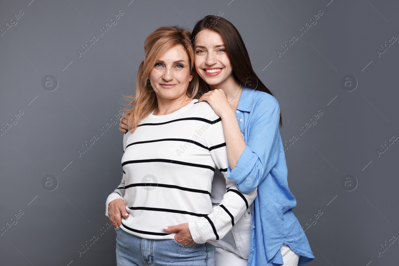 Portrait of mother and daughter on grey background Photo of Portrait of mother and daughter on grey background