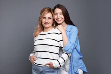 Photo of Portrait of mother and daughter on grey background