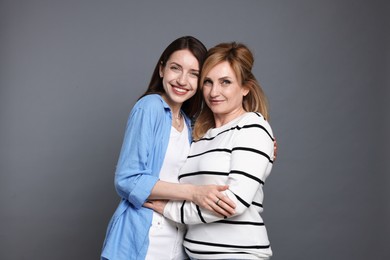 Photo of Portrait of mother and daughter on grey background