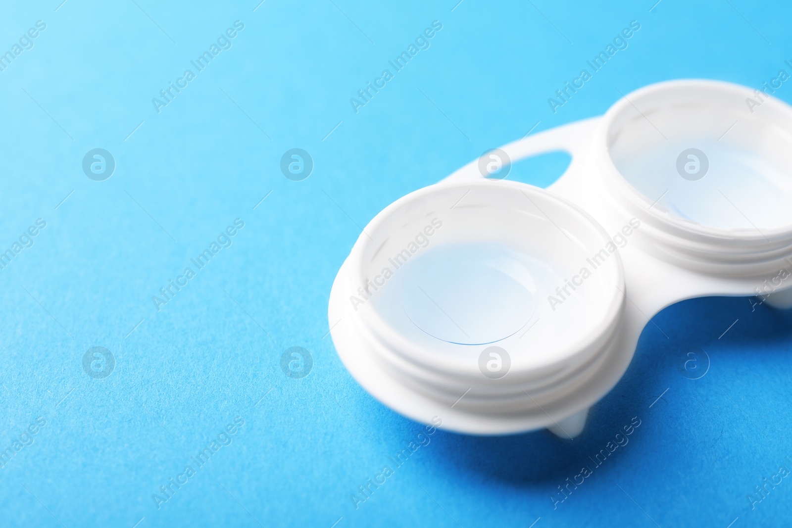 Contact lenses in case on light blue background, closeup. Space for text Photo of Contact lenses in case on light blue background, closeup. Space for text