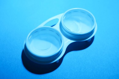 Photo of Contact lenses in case on light blue background, above view