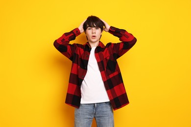 Photo of Portrait of teenage boy on orange background