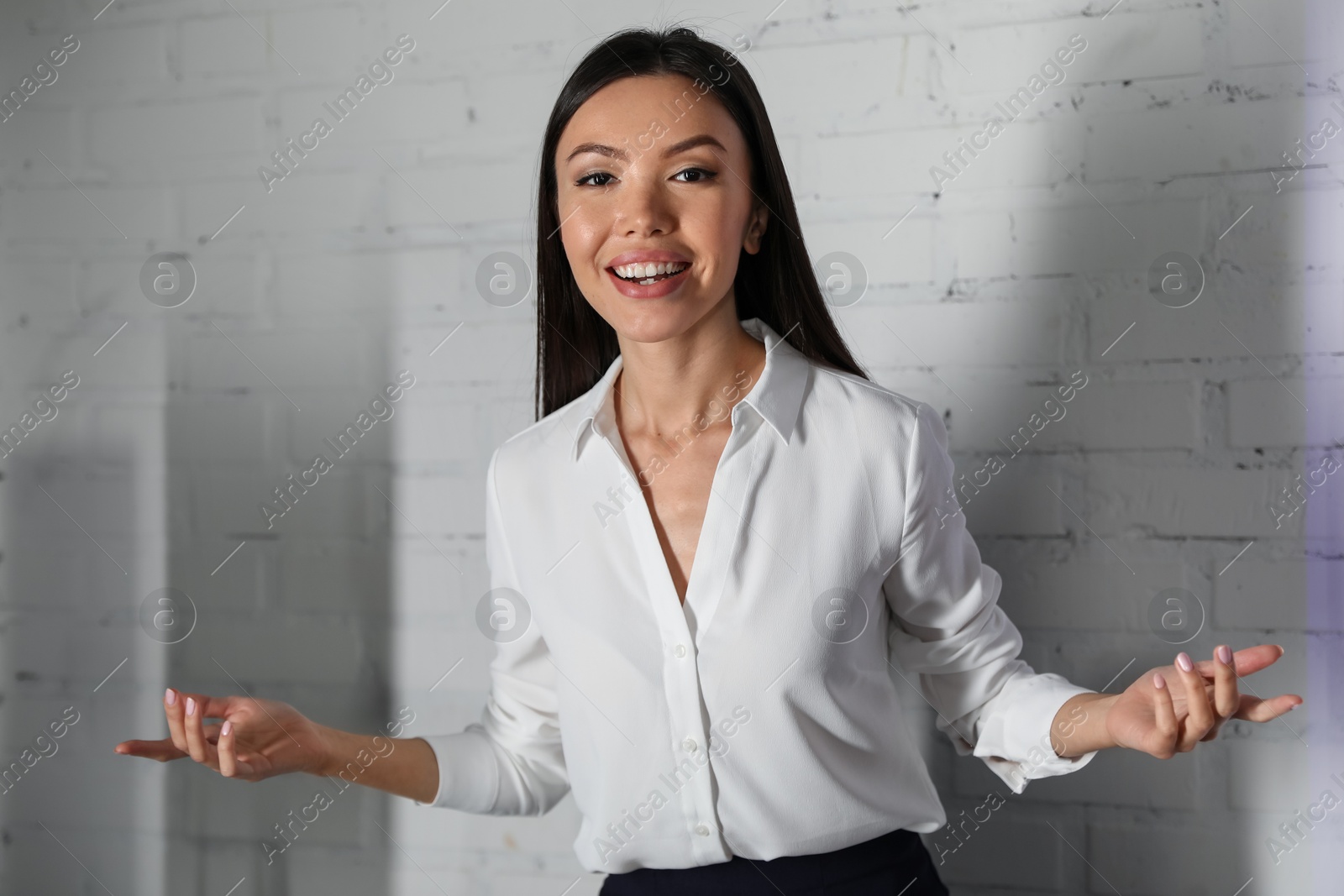 Young female business trainer near brick wall Photo of Young female business trainer near brick wall