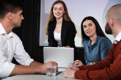 Photo of Business people having meeting in conference room with video projection screen
