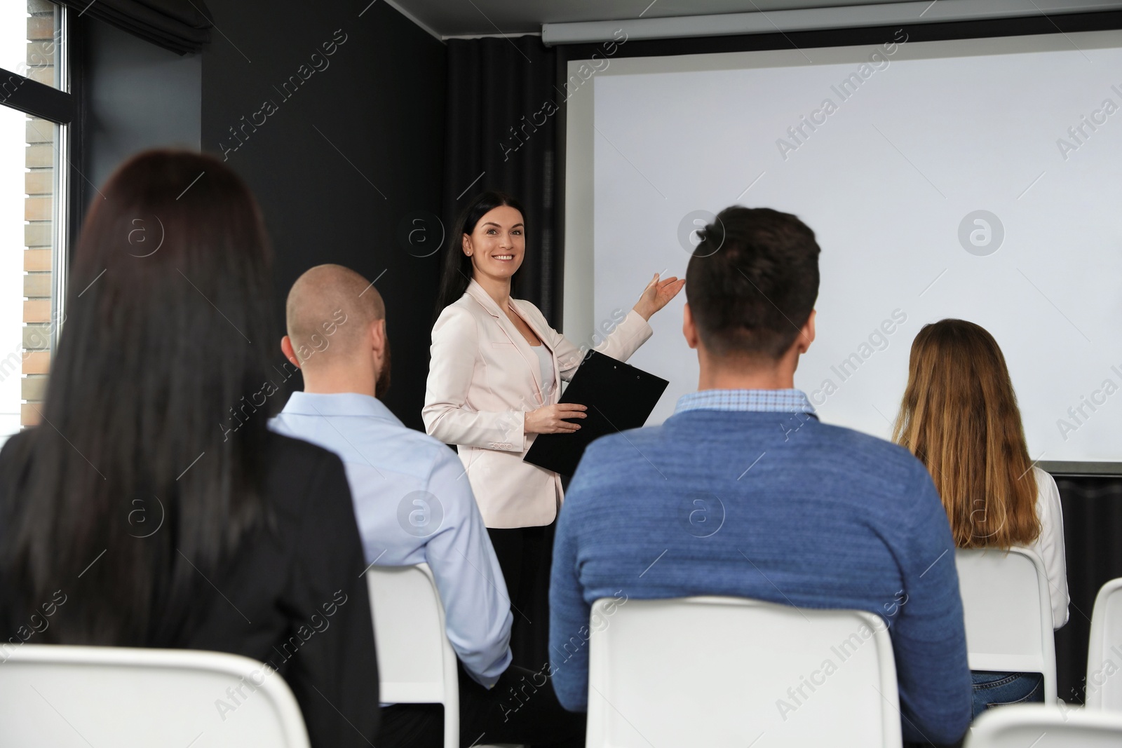 Business people at seminar in conference room with video projection screen Photo of Business people at seminar in conference room with video projection screen