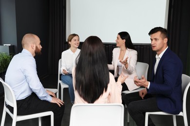Photo of Business people at seminar in conference room with video projection screen