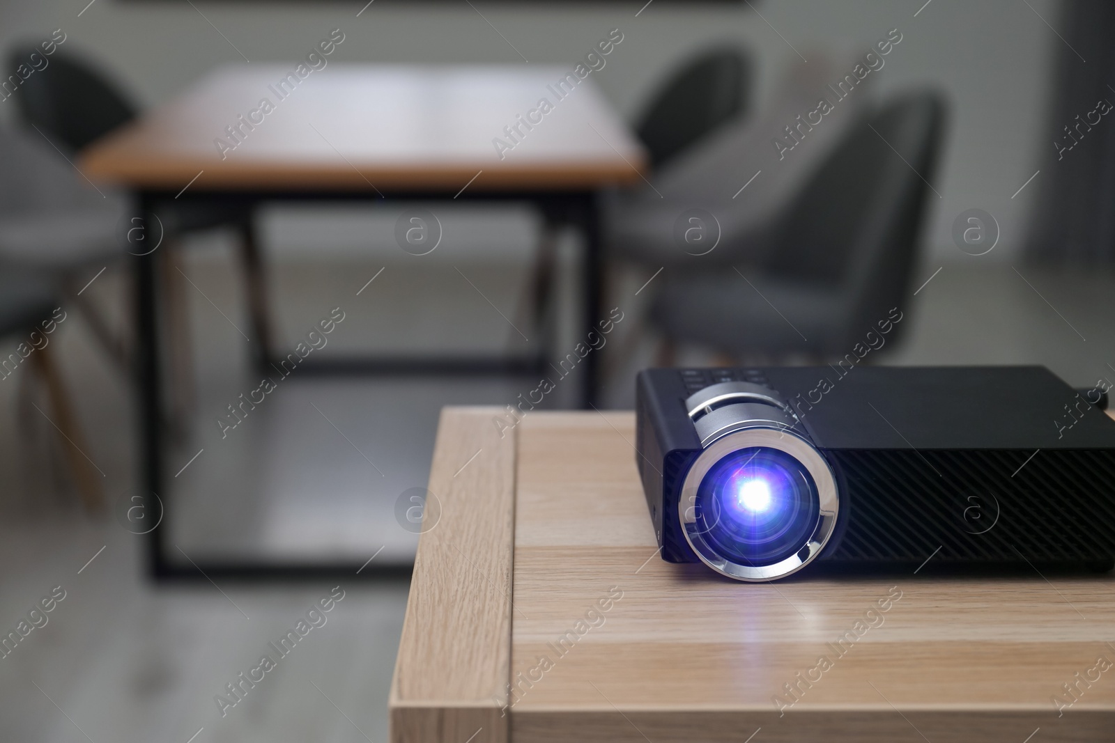Modern video projector on wooden table in conference room. Space for text Photo of Modern video projector on wooden table in conference room. Space for text