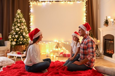 Photo of Family near video projector screen at home. Cozy Christmas atmosphere