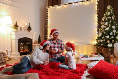 Photo of Father and daughter near video projector screen at home. Cozy Christmas atmosphere