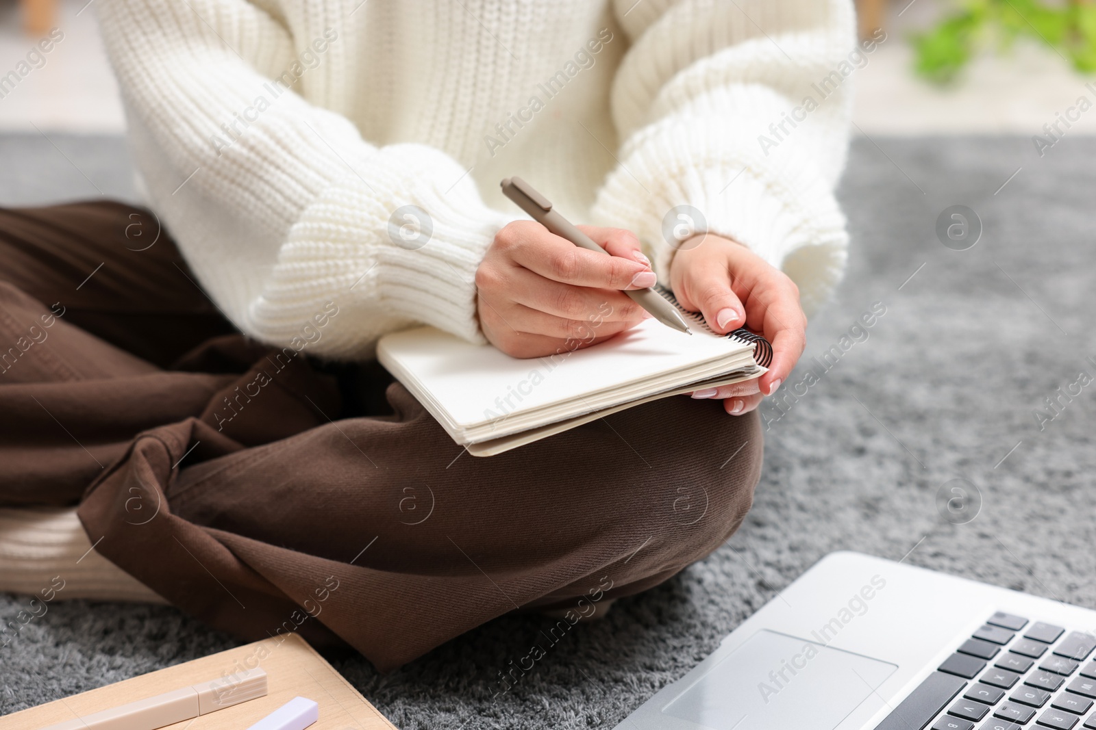 Woman with planner and laptop on floor indoors, closeup Photo of Woman with planner and laptop on floor indoors, closeup