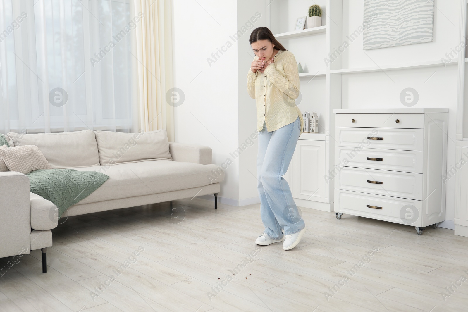 Emotional young woman looking in disgust at cockroaches on floor indoors. Pest problem Photo of Emotional young woman looking in disgust at cockroaches on floor indoors. Pest problem