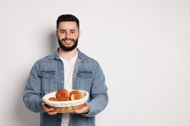 Photo of Gluten free diet. Man with pastries on light grey background, space for text