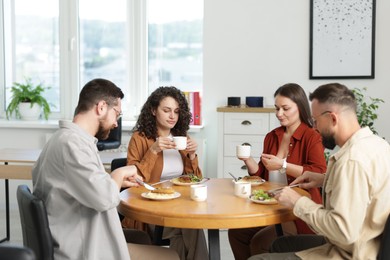 Photo of Colleagues chatting during lunch break in office