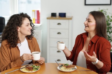 Photo of Colleagues chatting during lunch break in office