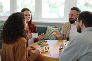 Photo of Colleagues chatting during lunch break in office