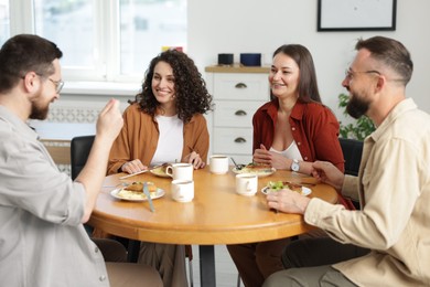 Photo of Colleagues chatting during lunch break in office