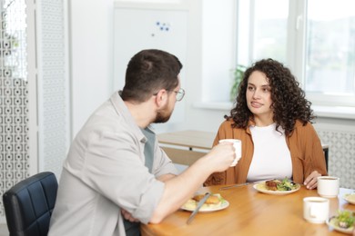 Photo of Colleagues chatting during lunch break in office