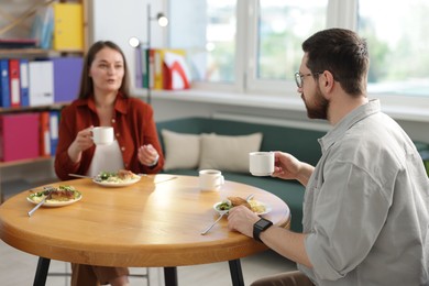 Photo of Colleagues chatting during lunch break in office