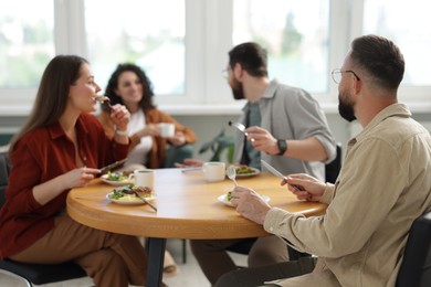 Photo of Colleagues chatting during lunch break in office