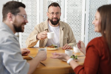 Photo of Colleagues chatting during lunch break in office