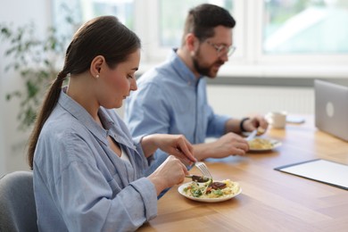 Photo of Colleagues eating during lunch break in office
