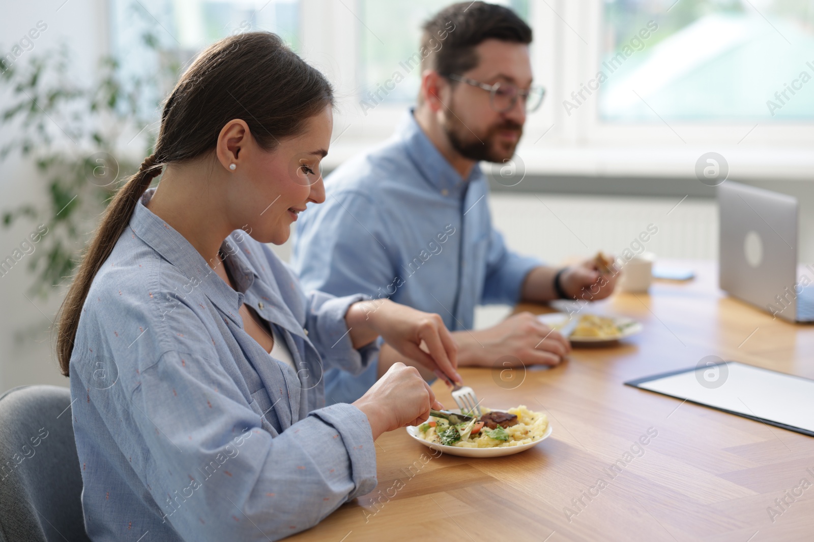 Colleagues eating during lunch break in office Photo of Colleagues eating during lunch break in office