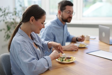 Photo of Colleagues eating during lunch break in office