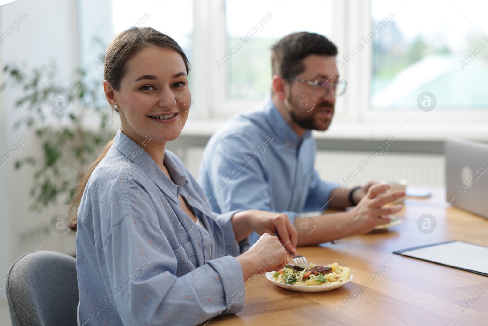 Colleagues eating during lunch break in office Photo of Colleagues eating during lunch break in office