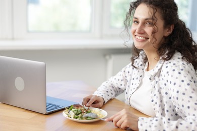 Photo of Woman with meal at table during lunch break in office. Space for text