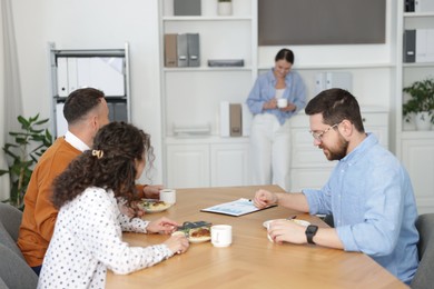 Photo of Colleagues eating and chatting during lunch break in office