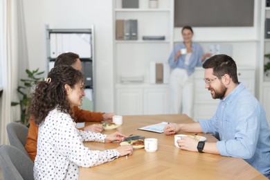 Photo of Colleagues eating and chatting during lunch break in office