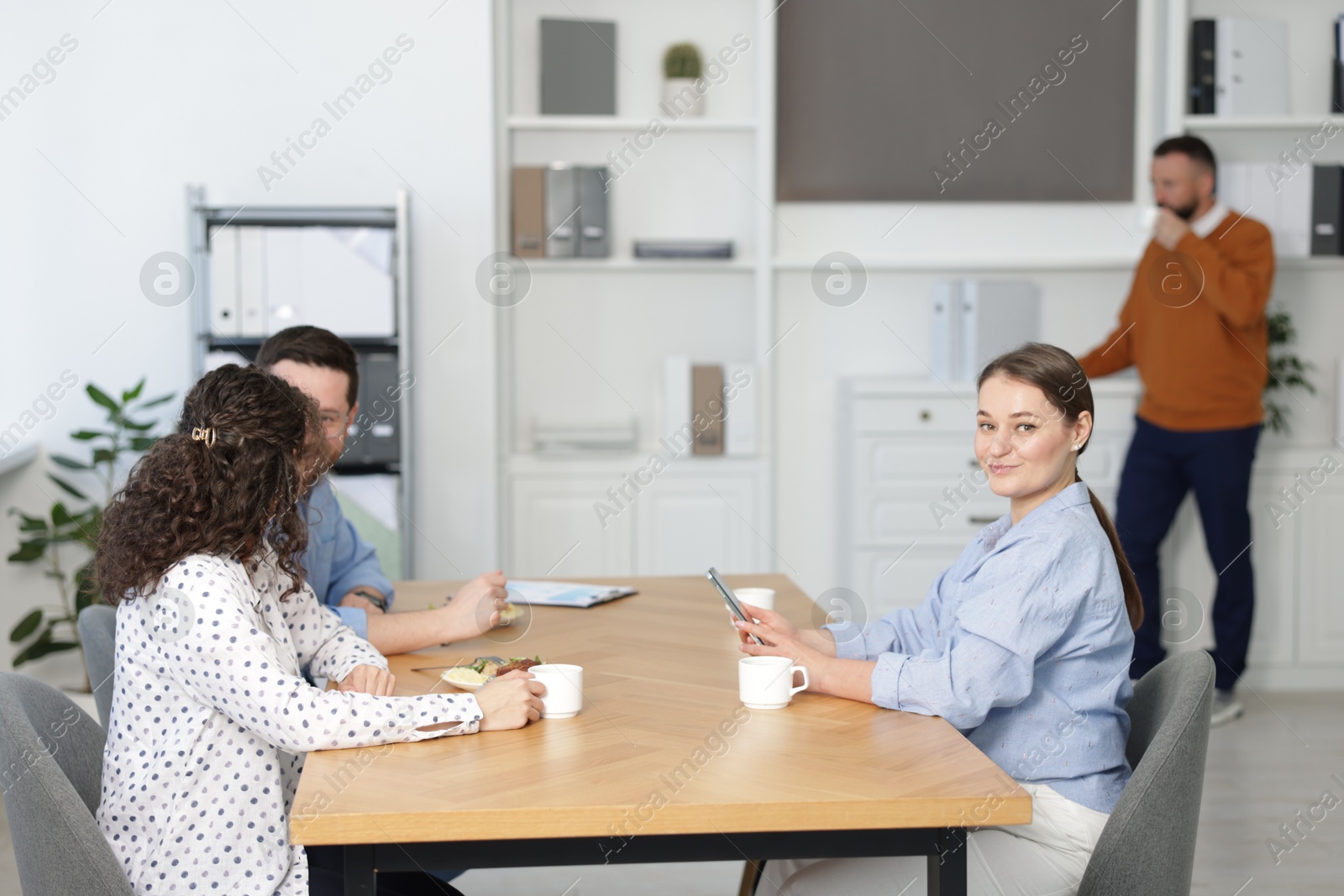 Colleagues eating during lunch break in office Photo of Colleagues eating during lunch break in office