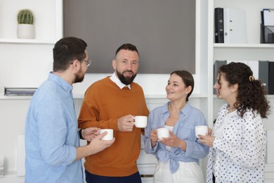 Photo of Colleagues chatting during coffee break in office