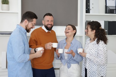 Photo of Colleagues chatting during coffee break in office