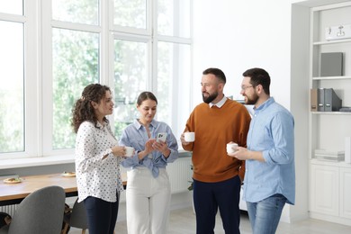 Photo of Colleagues chatting during coffee break in office