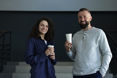 Photo of Colleagues with coffee on stairs in office during break
