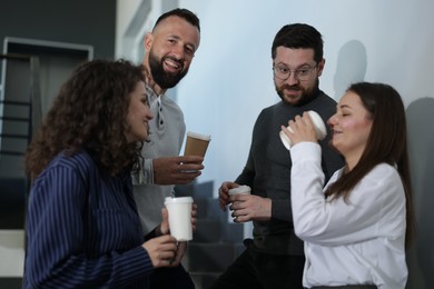 Photo of Colleagues with coffee on stairs in office during break