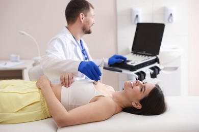 Photo of Sonographer conducting ultrasound examination of woman's heart in clinic