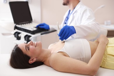 Photo of Sonographer conducting ultrasound examination of woman's heart in clinic, closeup