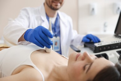 Photo of Sonographer conducting ultrasound examination of woman's heart in clinic, closeup
