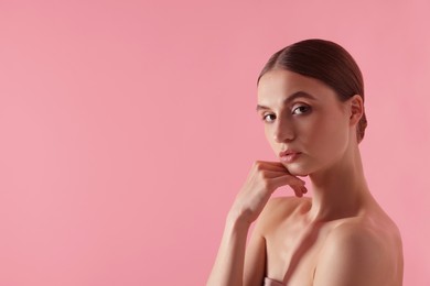 Photo of Portrait of beautiful young woman on pink background. Space for text