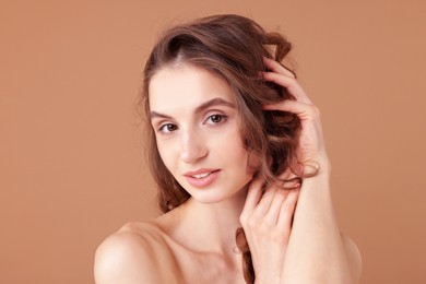 Photo of Portrait of beautiful young woman on beige background